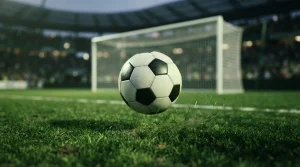 Ein Fußball fliegt über dem Rasen vor einem unscharfen Tor